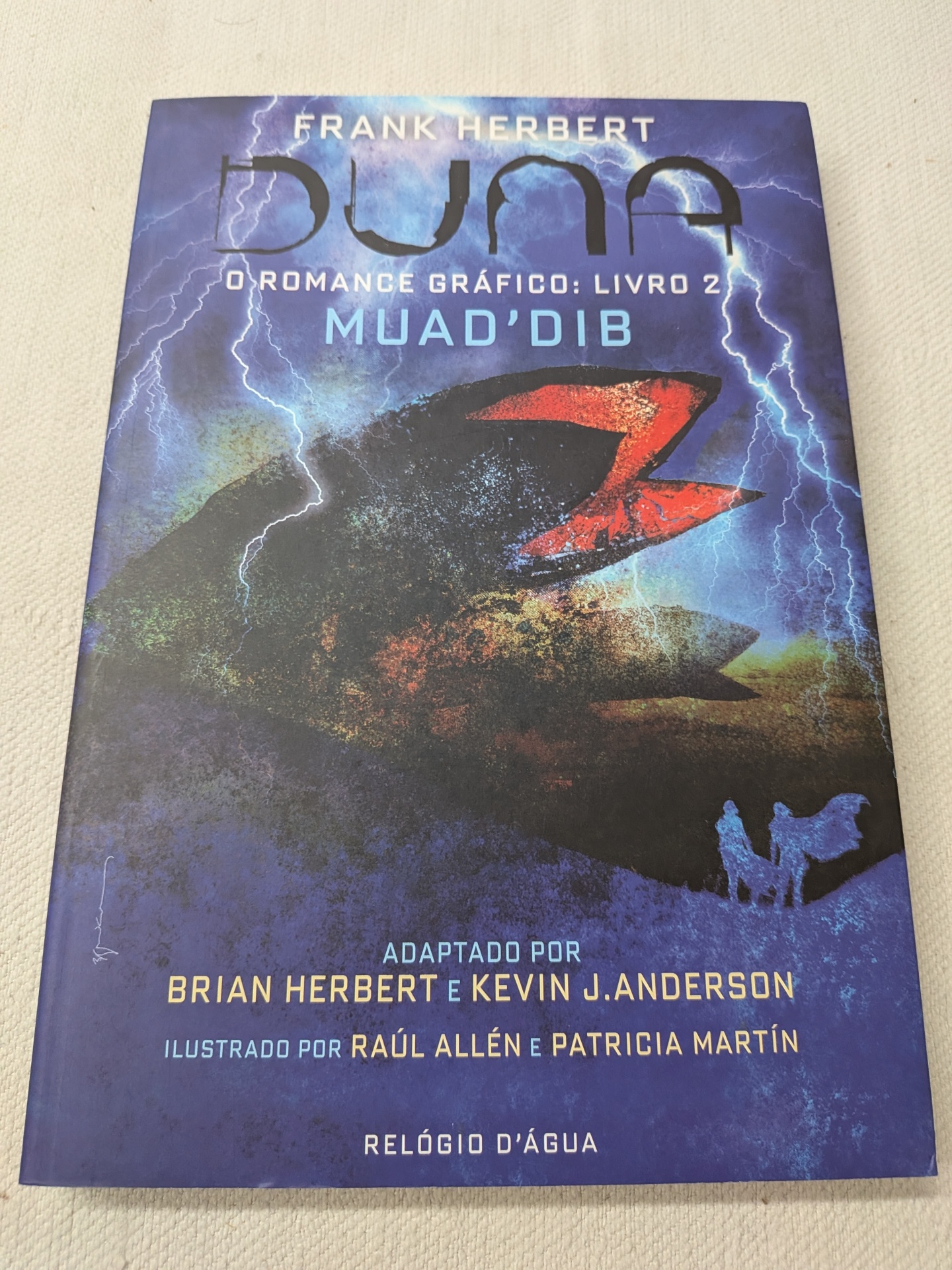 Frank Herbert, Brian Herbert e Kevin J. Anderson - Duna - O Romance Gráfico: Livro 2 Muad’Dib Capa do livro gráfico DUNE O ROMANCE GRÁFICO: LIVRO 2 MUADDIB com fundo azul e preta e relâmpagos