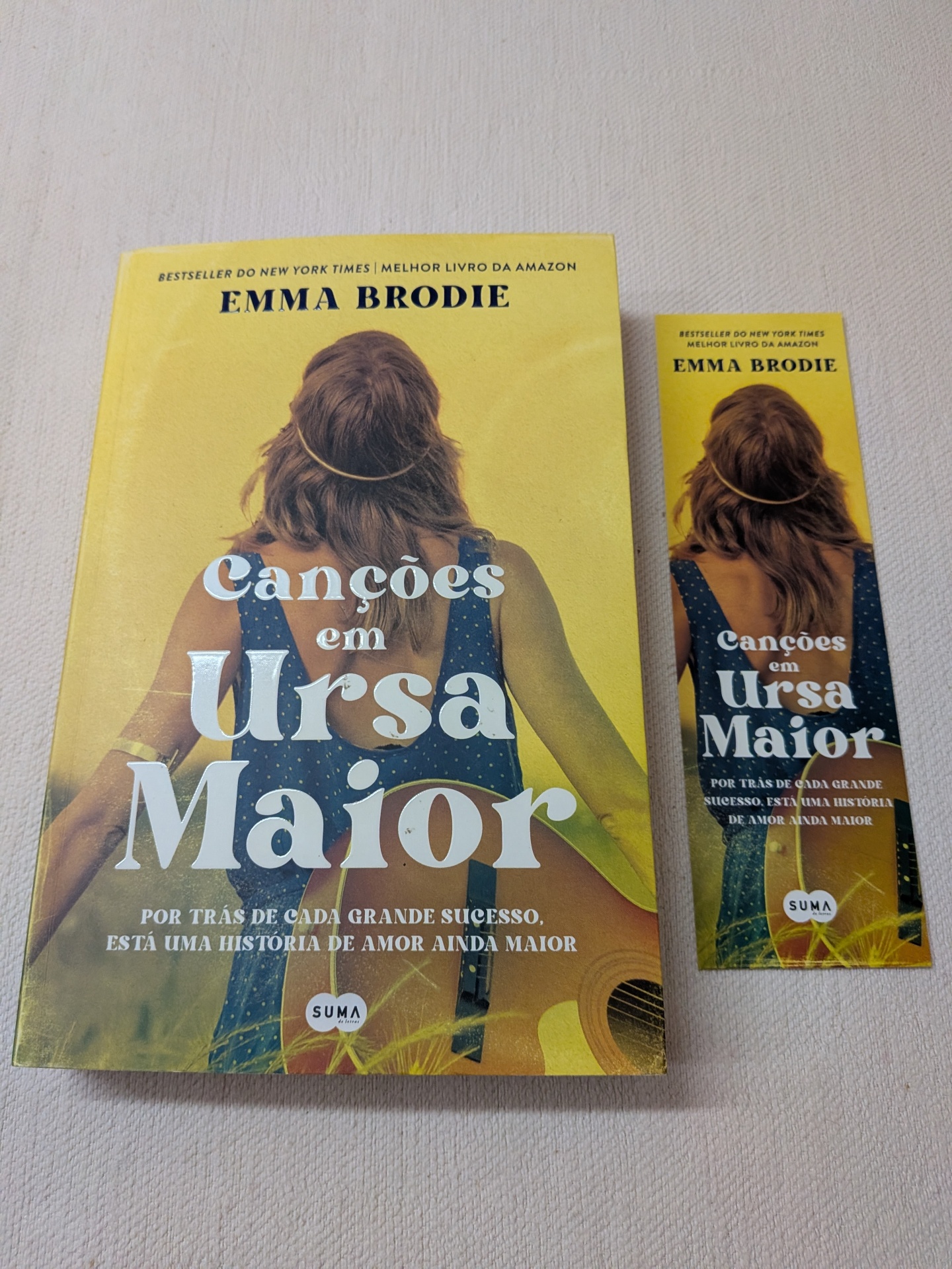 Emma Brodie - Canções em Ursa Maior Livro e marcador de livros Canções em Ursa Maior de Emma Brodie com capa amarela e mulher de costas