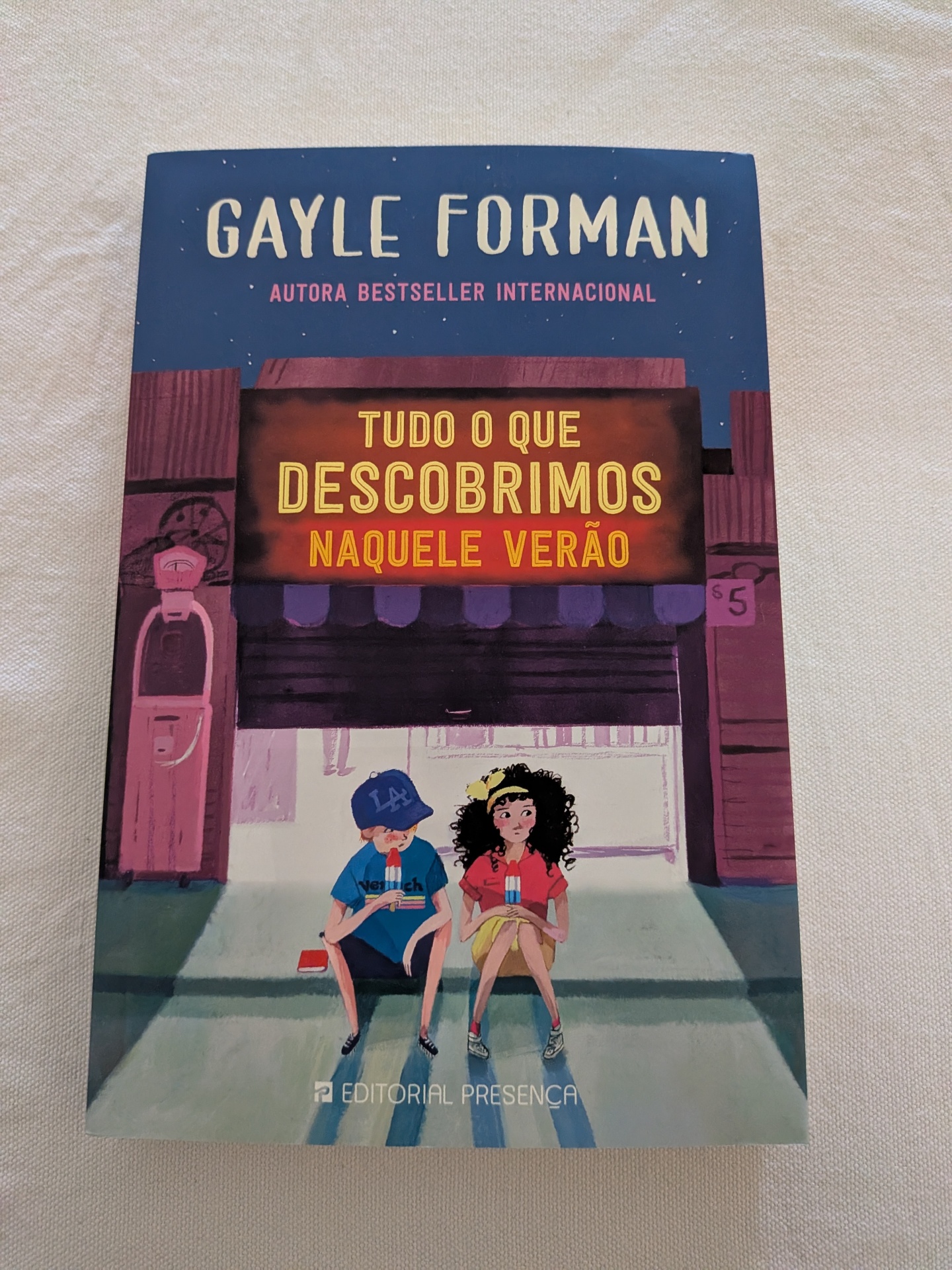 Gayle Forman - Tudo o que Descobrimos Naquele Verão Capa do livro Tudo o que descobrimos naquele verão de Gayle Forman com ilustração de dois jovens a comer gelados.