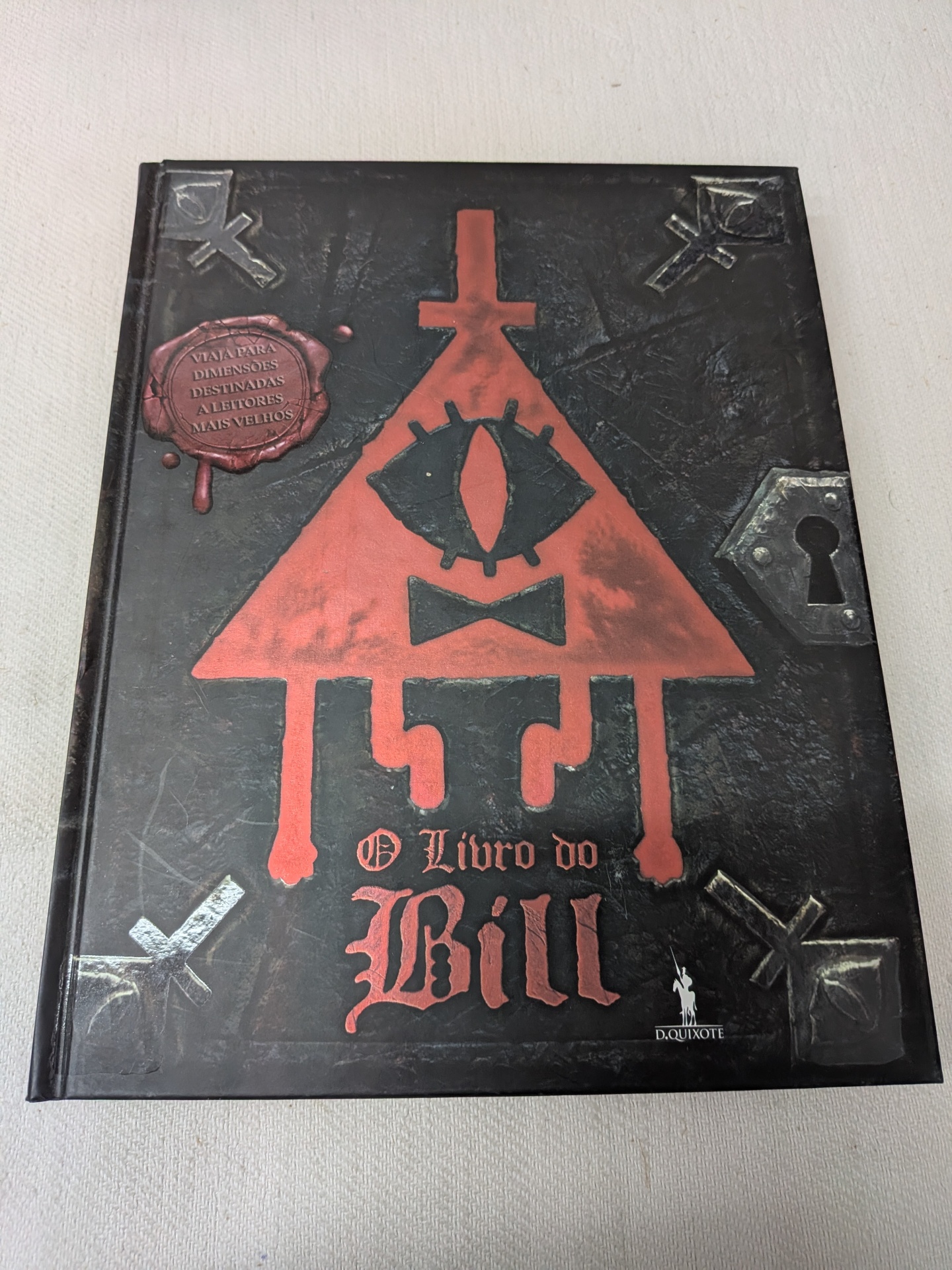 Alex Hirsch - O Livro do Bill Livro preto com figura triangular vermelha e título O Livro do Bill em capa texturada.