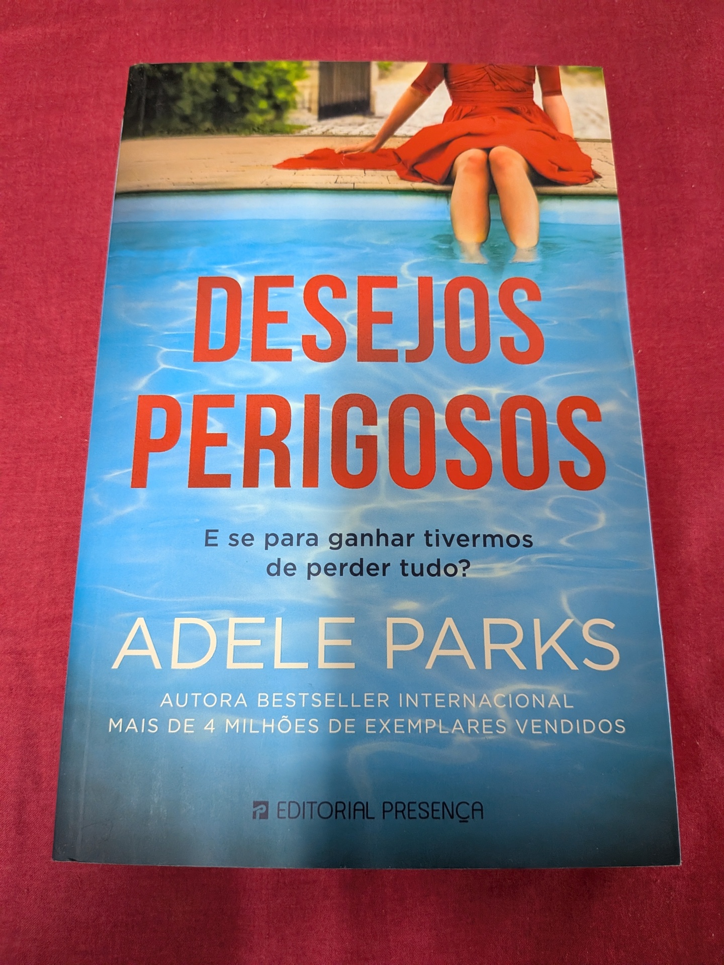 Desejos Perigosos de Adele Parks Capa do livro Desejos Perigosos de Adele Parks com mulher de vestido vermelho junto a piscina