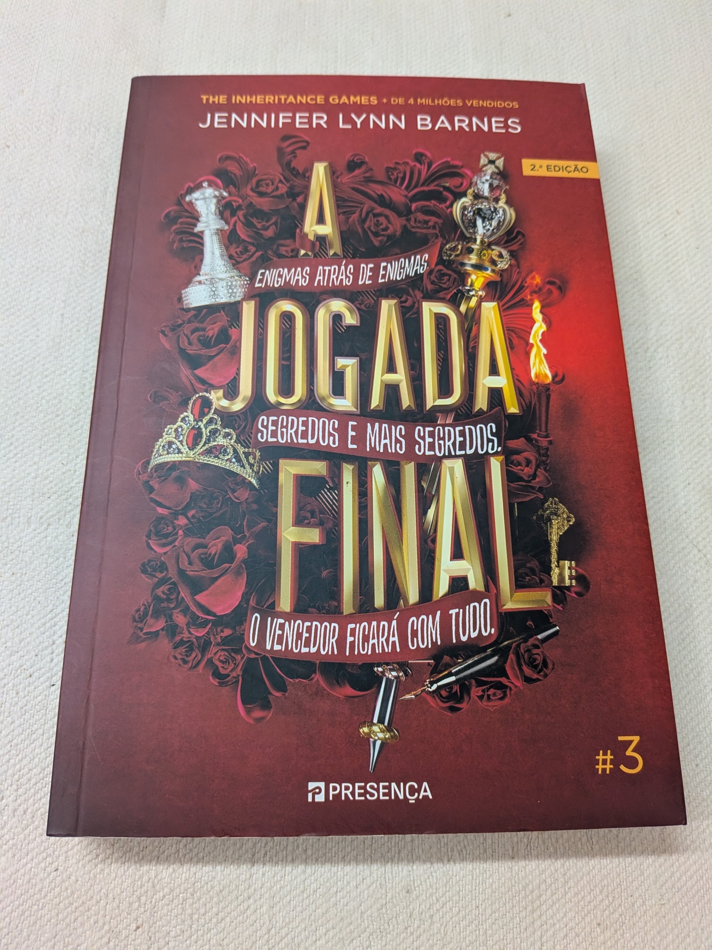 Jennifer Lynn Barnes - A Jogada Final (Os Jogos da Herança 3) (defeito na capa) Capa de livro vermelha com coroas, rosas e texto A JOGADA FINAL de Jennifer Lynn Barnes