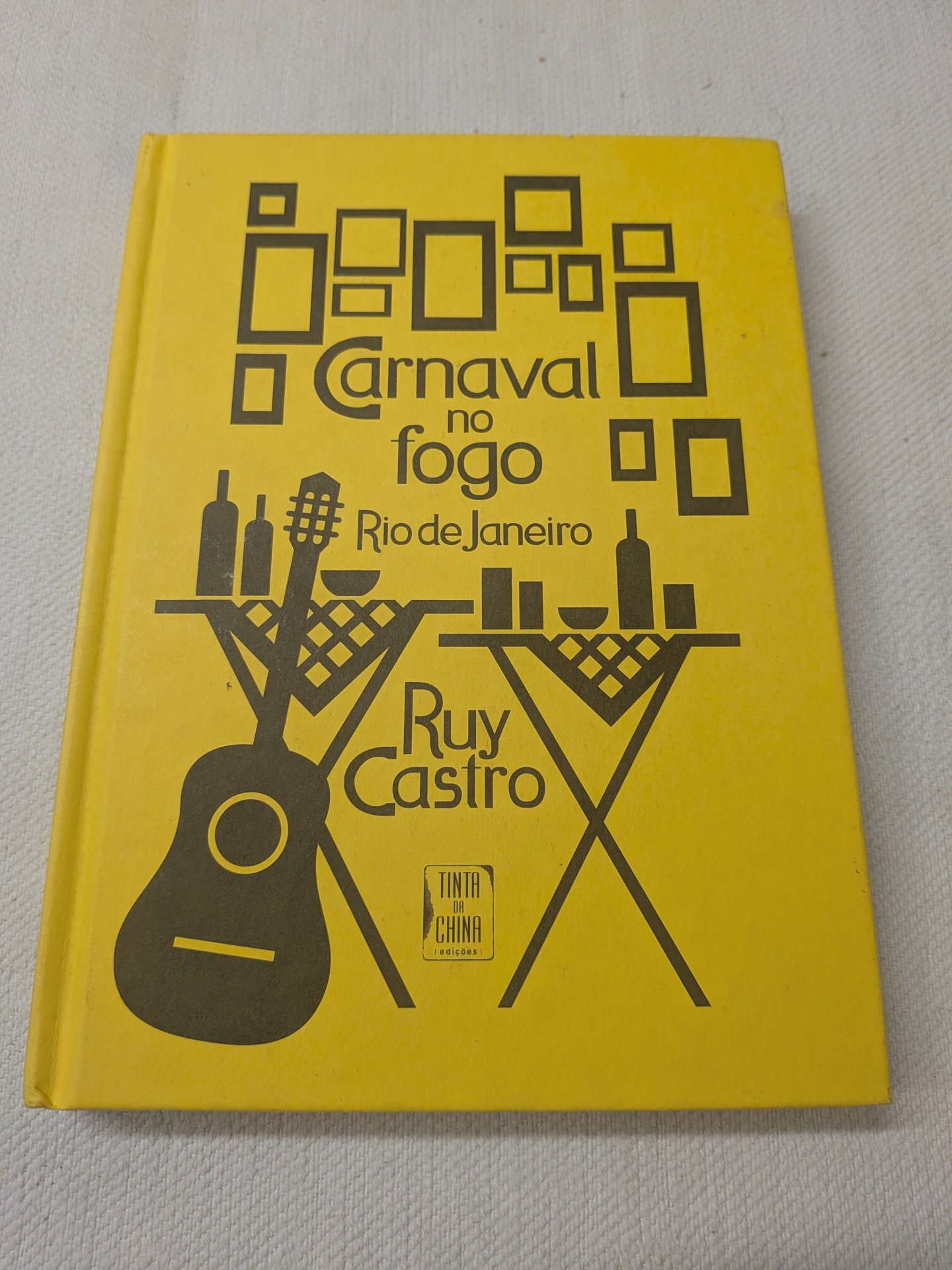 Ruy Castro - Carnaval no Fogo (Crónica de uma cidade excitante demais) Livro amarelo Carnaval no fogo com ilustrações a preto e texto na capa.