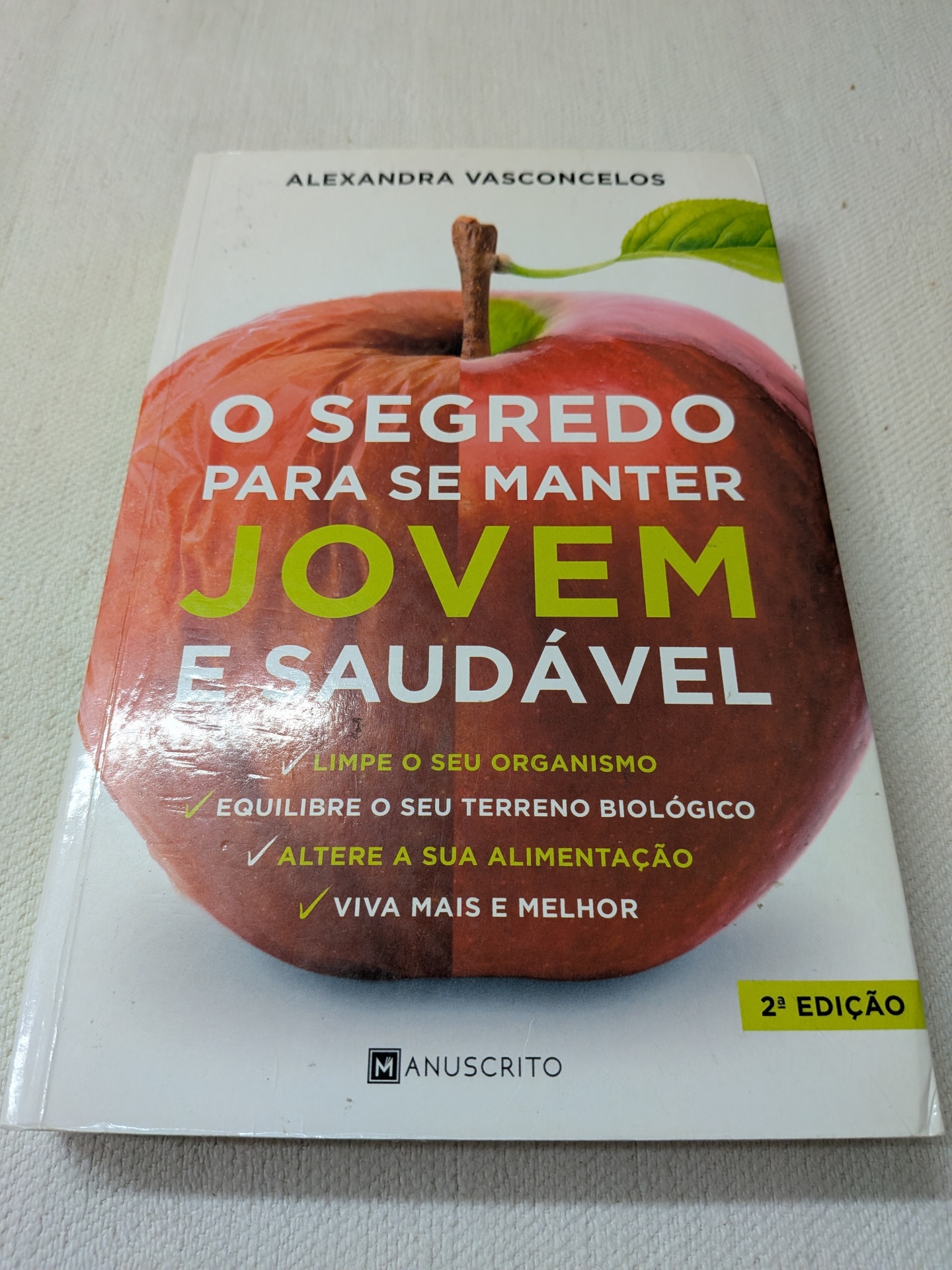 Alexandra Vasconcelos - O Segredo para se Manter Jovem e Saudável Capa de livro com maçã e texto em português