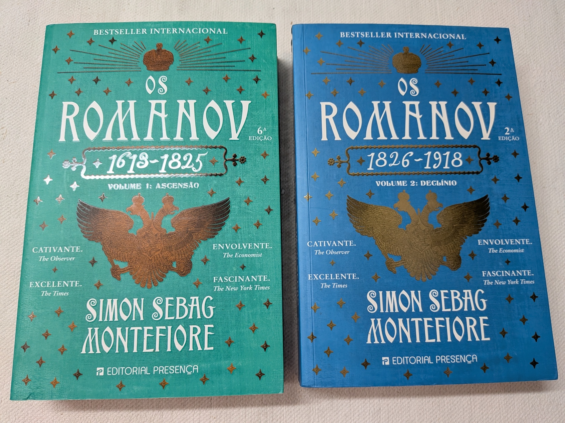 Simon Sebag Montefiore - Os Romanov (1613-1825) Volume 1 - Ascensão + Os Romanov (1826 -1918) Volume 2 - Declínio Dois livros Os Romanov de Simon Sebag Montefiore, capas verde e azul, com textos brancos e dourados.