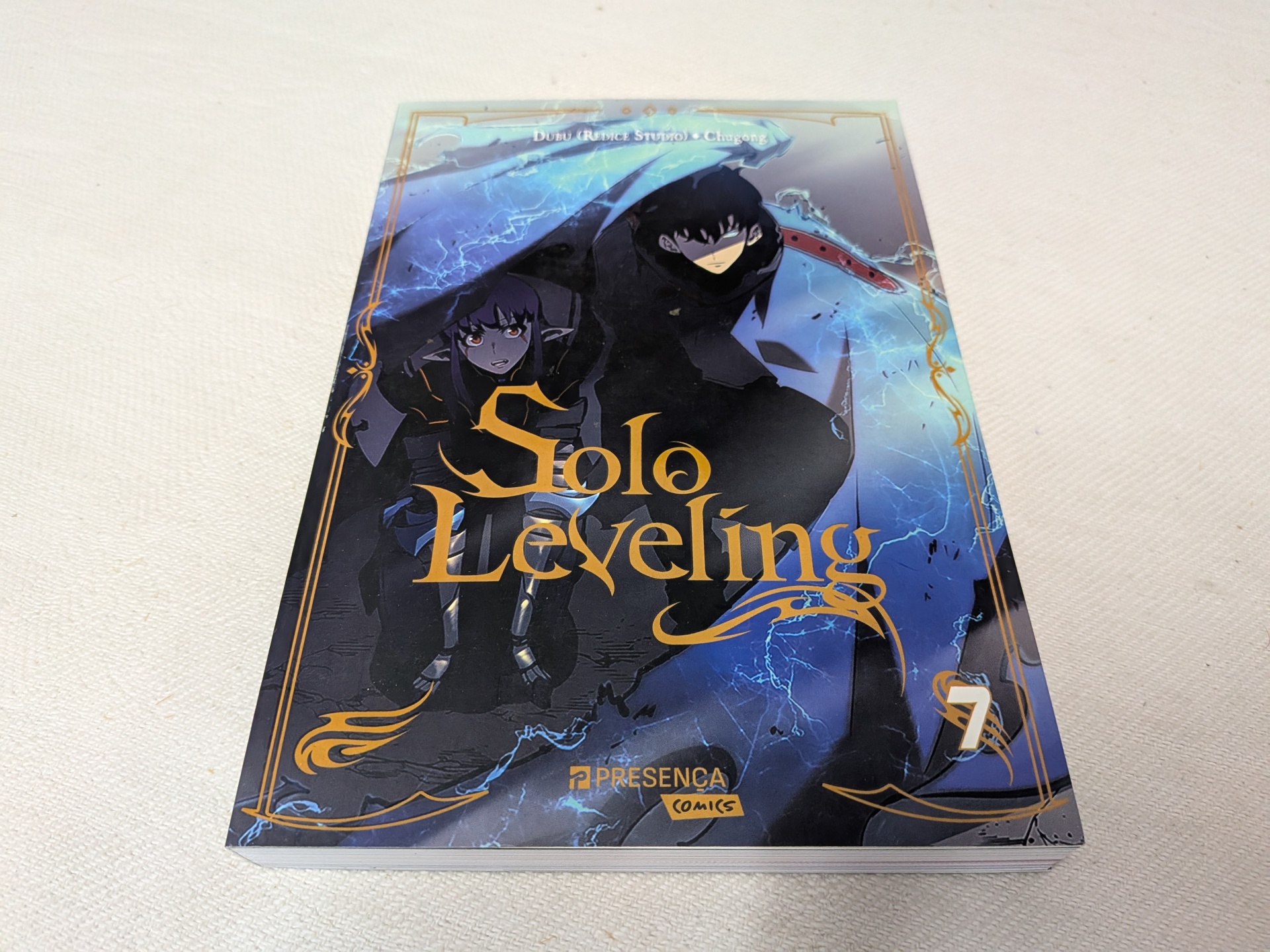 Chugong - Solo Leveling Volume 7 Capa do volume 7 da banda desenhada Solo Leveling com personagens e efeitos de luz azul