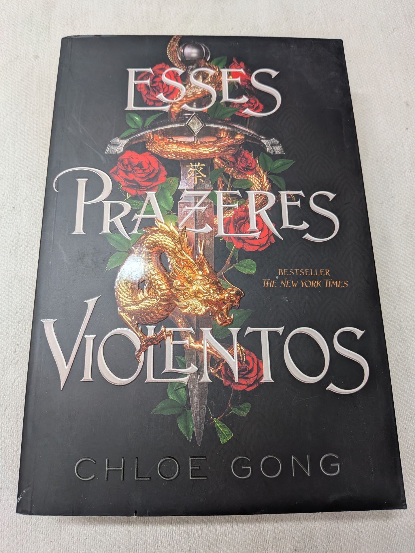 Chloe Gong - Esses Prazeres Violentos Livro de capa preta com espada, dragão dourado e rosas, título ESSES PRAZERES VIOLENTOS e autor Chloe Gong.