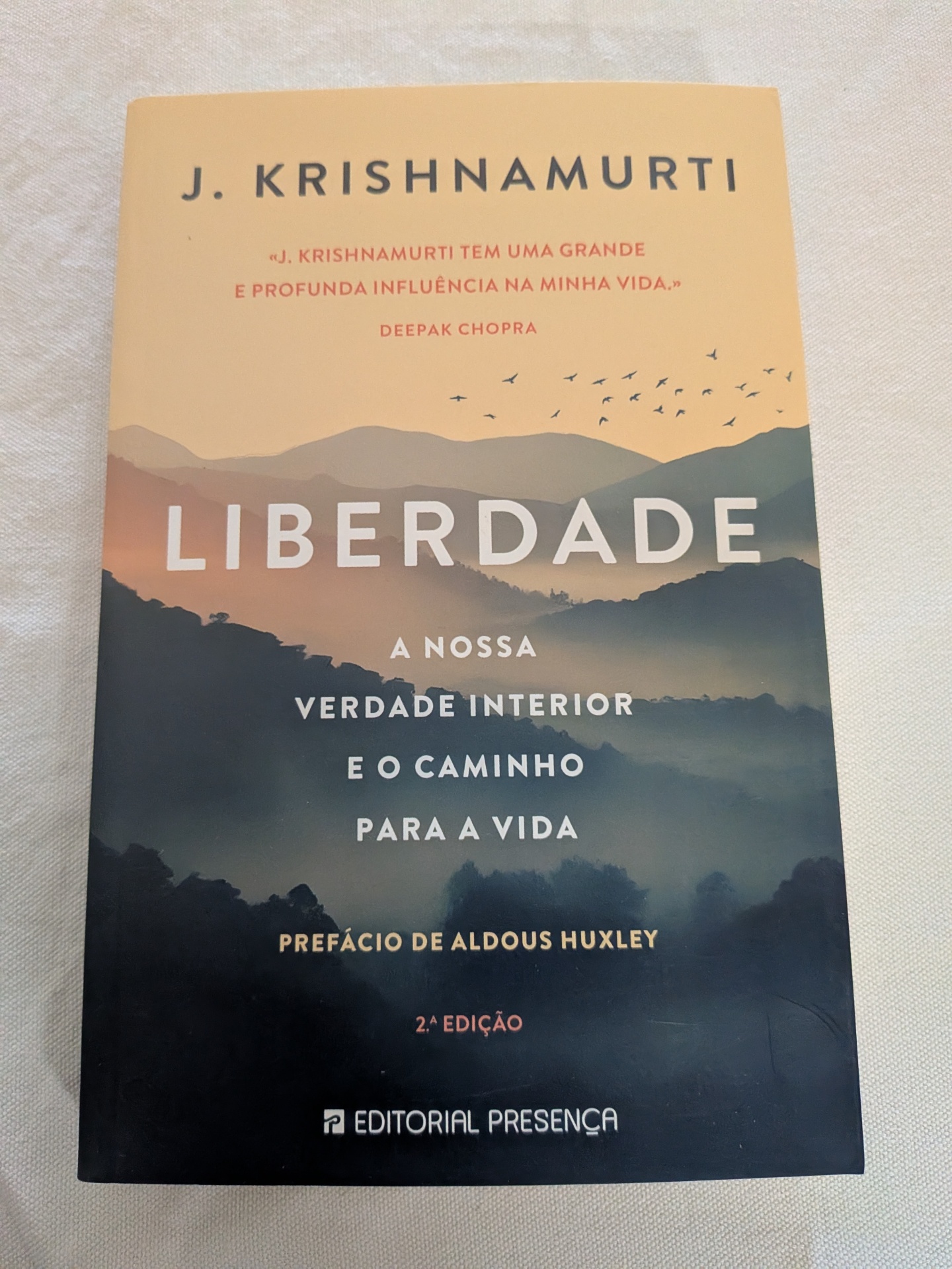 J. Krishnamurti - Liberdade (A nossa verdade interior e o caminho para a vida) Capa de livro LIBERDADE de J. Krishnamurti com montanhas e pássaros em fundo vazio.
