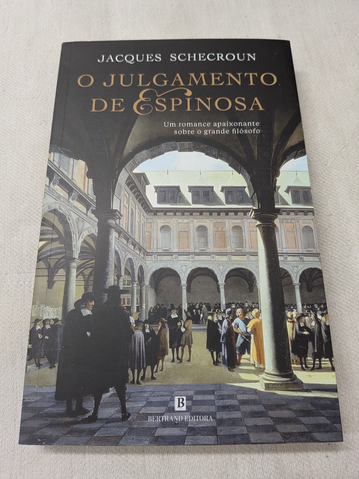 Jacques Schecroun - O Julgamento de Espinosa Capa do livro O Julgamento de Espinosa com ilustração de pátio histórico e pessoas em trajes antigos