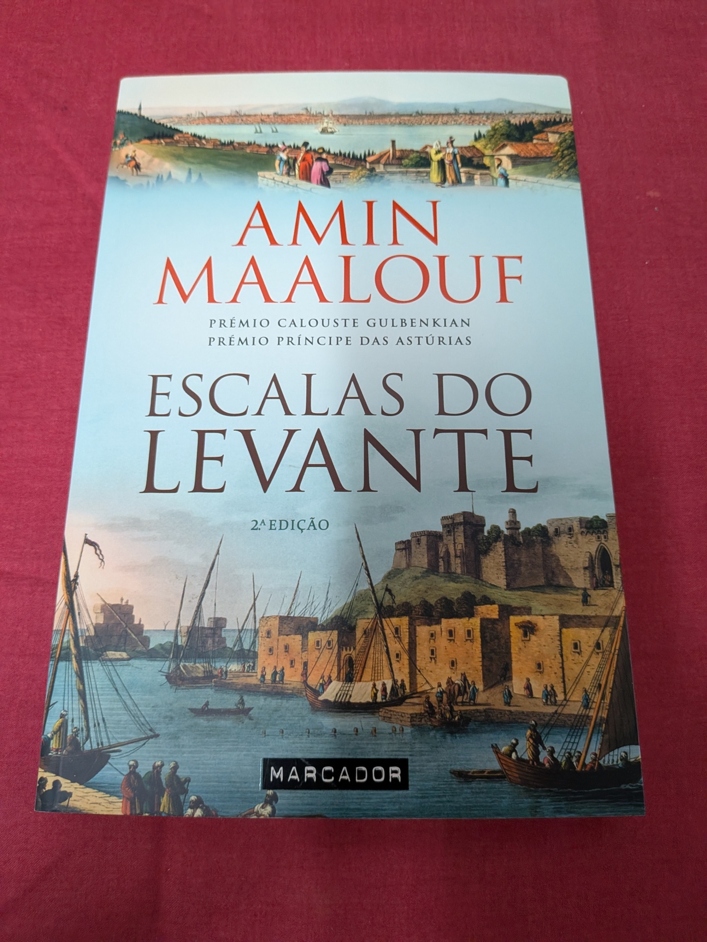 Escalas do Levante de Amin Maalouf Capa de livro com pintura de porto histórico e texto em vermelho e preto