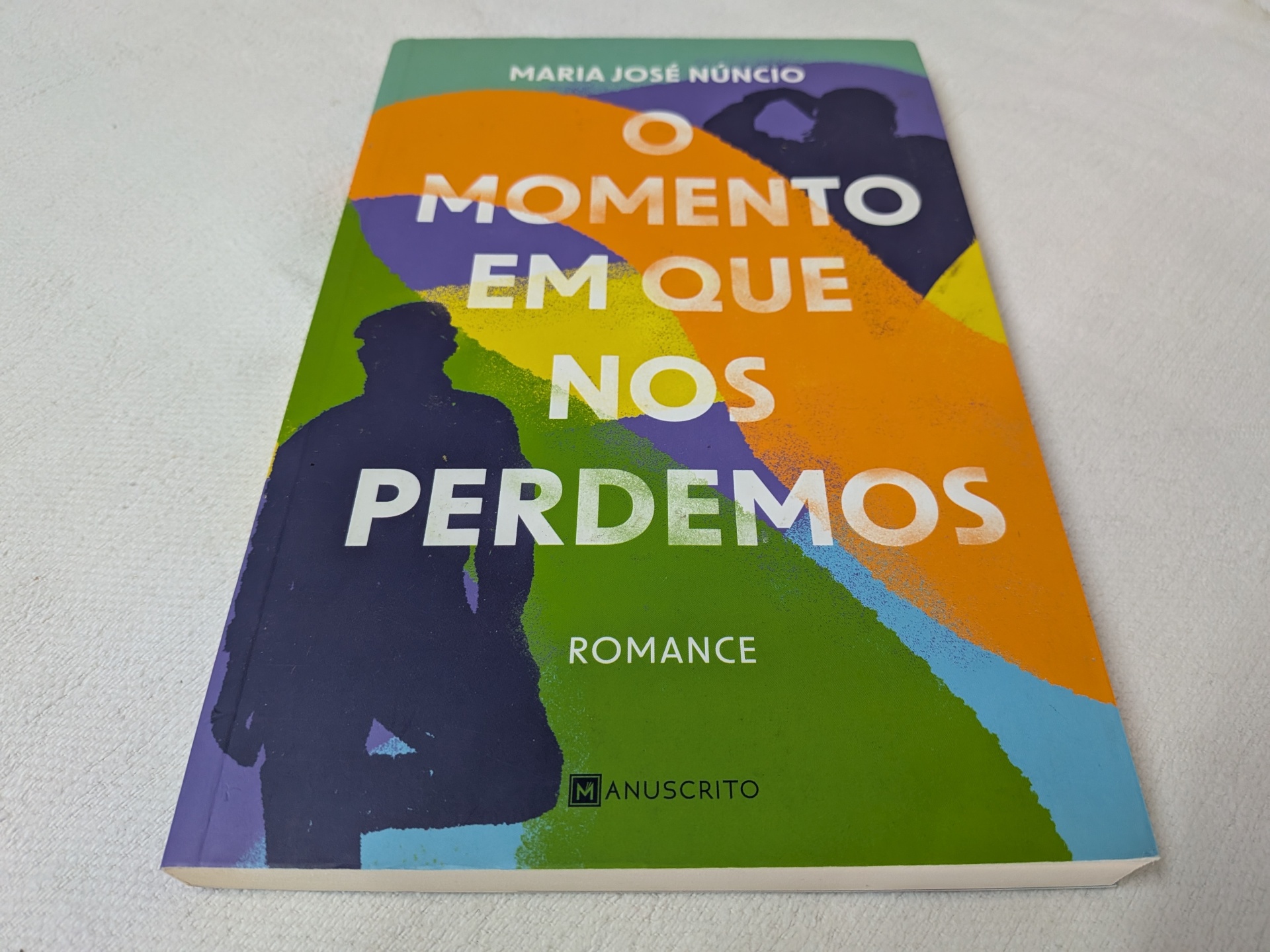 Maria José Núncio - O Momento em que Nos Perdemos Capa do livro 'O MOMENTO EM QUE NOS PERDEMOS' de Maria José Núncio com design colorido.
