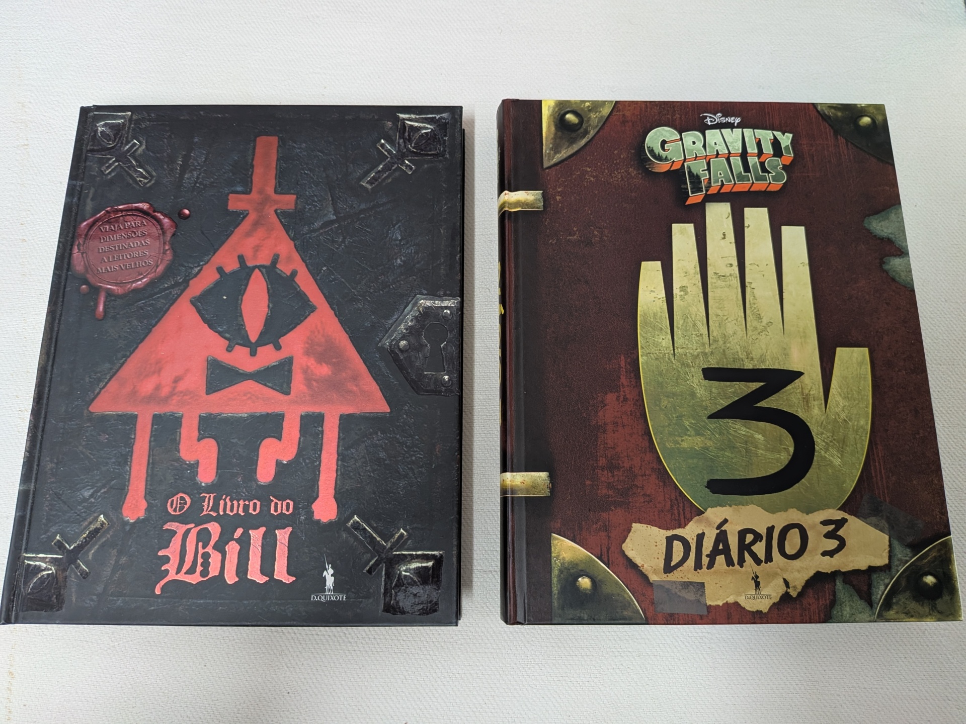 Gravity Falls Pack - Diário 3 + O Livro do Bill Capas de livros O Livro do Bill e Gravity Falls Diário 3 sobre uma superfície branca