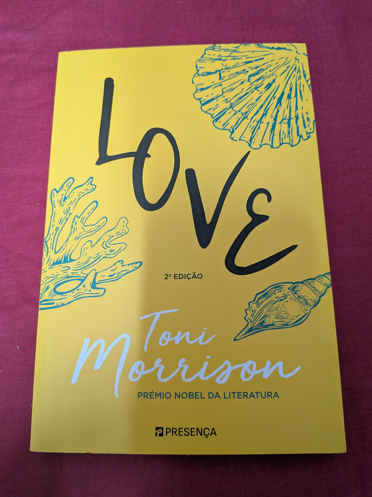 Love de Toni Morrison Capa de livro amarela com ilustrações azuis e texto preto e branco
