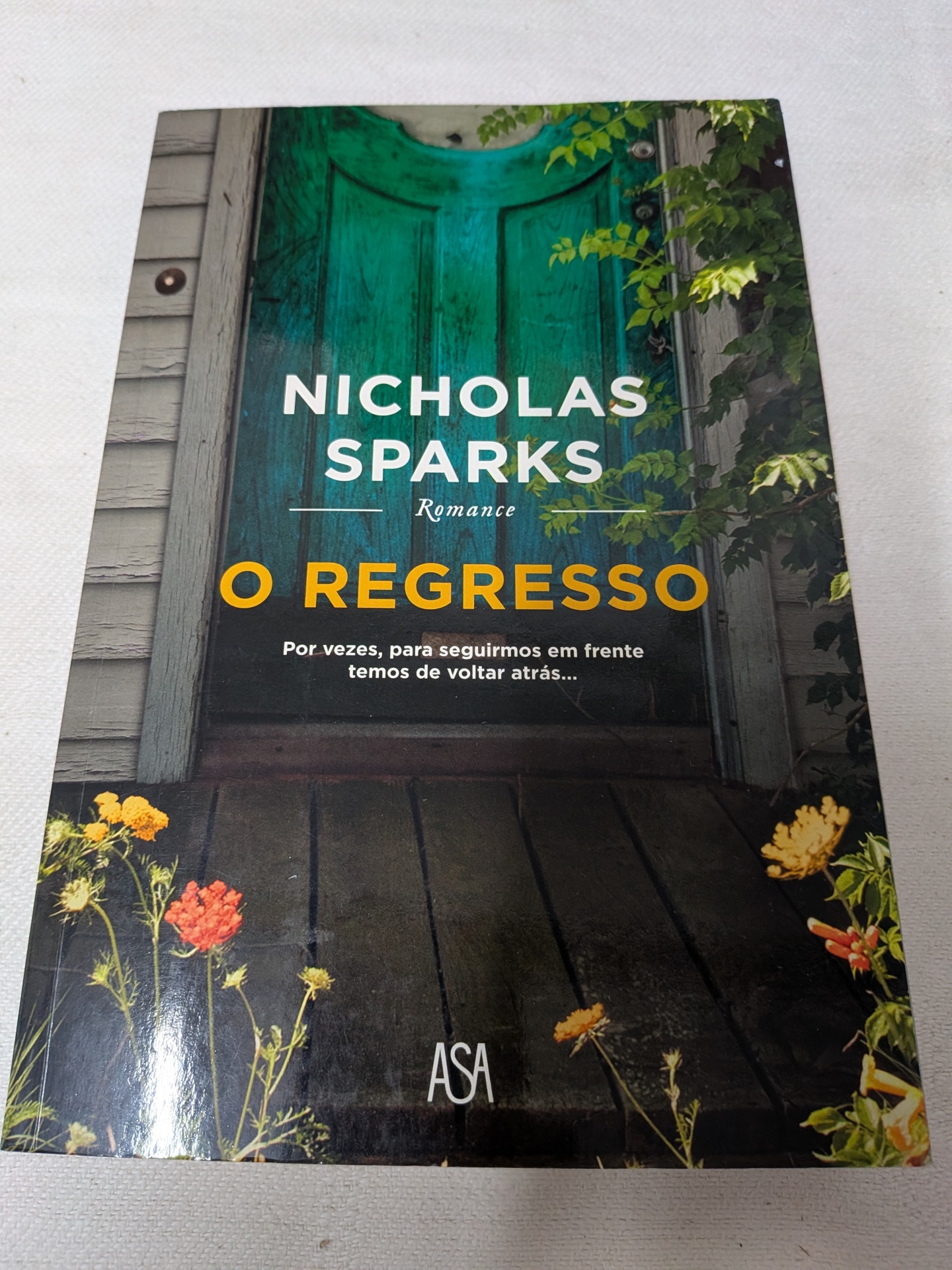 Nicholas Sparks - O Regresso Capa de livro O REGRESSO com porta verde e flores ao redor