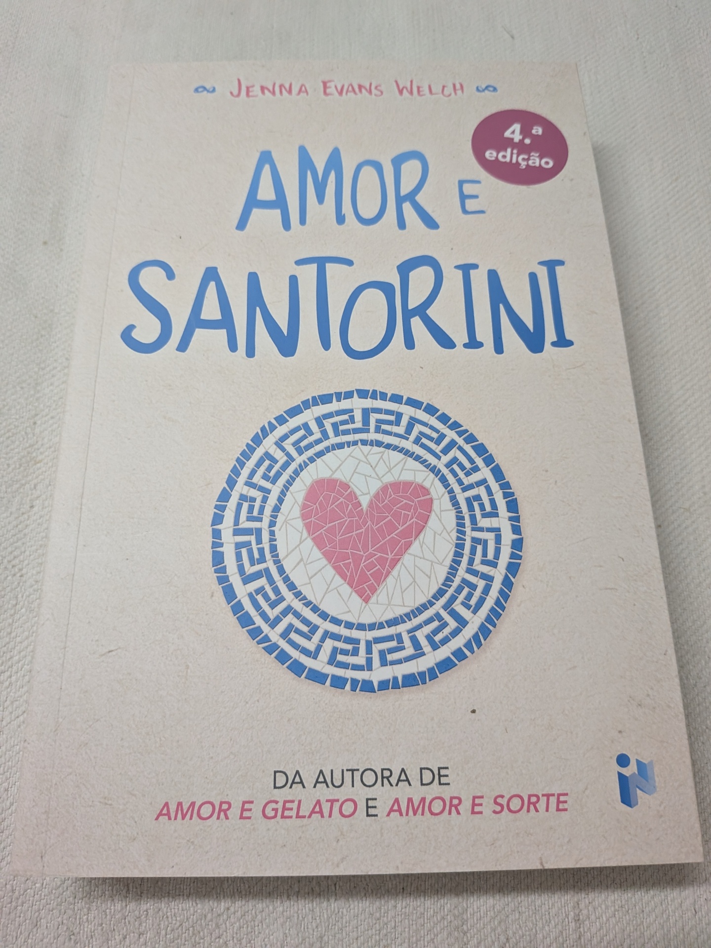 Jenna Evans Welch - Amor e Santorini Capa do livro Amor e Santorini com texto azul e rosa e coração de mosaicos.
