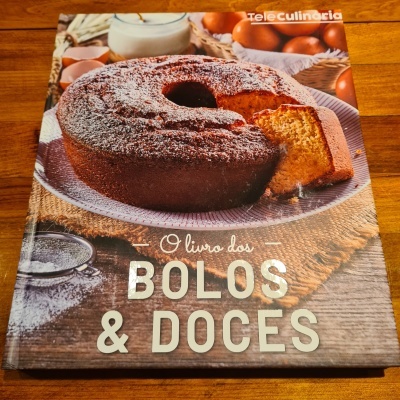 Capa de livro com foto de bolo redondo com açúcar em pó e fatias ao lado