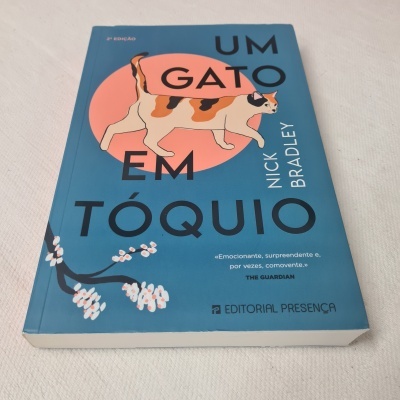 Livro azul com gato malhado na capa e texto 'UM GATO EM TÓQUIO'.