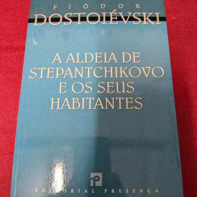 Livro azul de Fiódor Dostoiévski sobre fundo vermelho