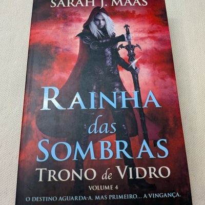 Capa de livro Rainha das Sombras de Sarah J. Maas com personagem segurando espada e fundo vermelho