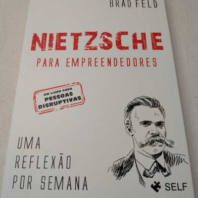 Capa de livro Nietzsche para Empreendedores, com texto em vermelho e preto e ilustração de rosto masculino.