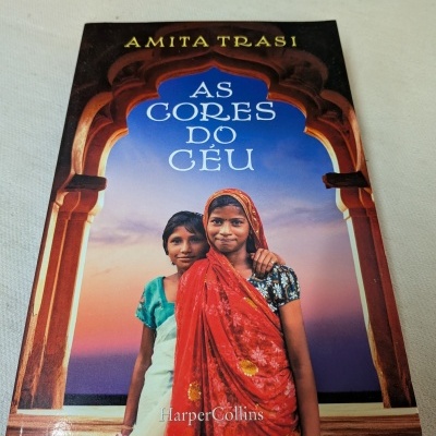 Capa de livro com duas raparigas em frente a um arco decorativo