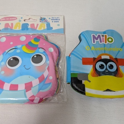 Dois livros infantis em material plástico para banho com narval rosa e personagem Milo em carro amarelo