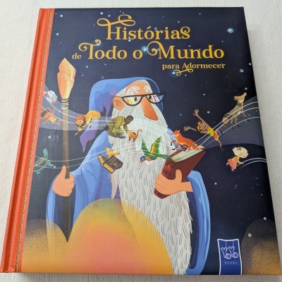 Livro infantil com capa ilustrada de velho com barba e óculos segurando livro com personagens saindo dele