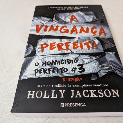 Livro 'A VINGANÇA PERFEITA' de Holly Jackson sobre mesa branca