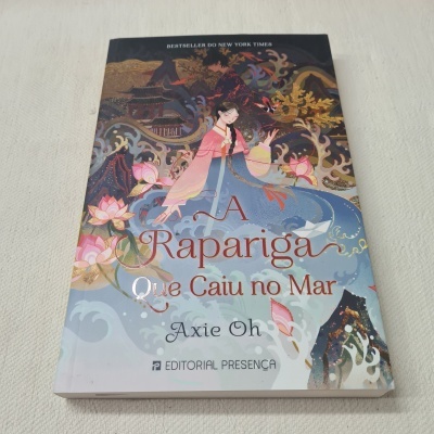 Capa do livro 'A Rapariga Que Caiu no Mar' com ilustração colorida de mulher em traje tradicional e elementos florais