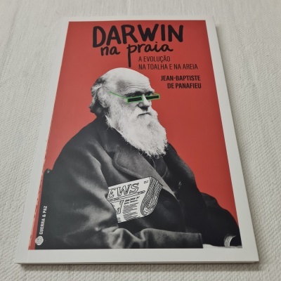 Capa de livro vermelho com foto em preto e branco de Darwin de óculos verdes e texto preto