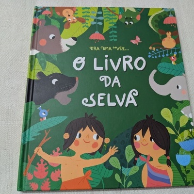 Capa de livro infantil verde com ilustrações de animais da selva e duas crianças