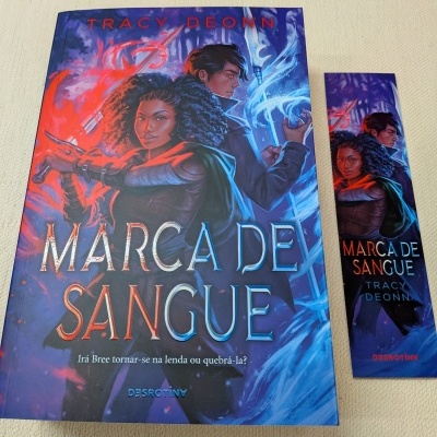 Livro Marca de Sangue de Tracy Deonn com capa colorida e marcador de livros