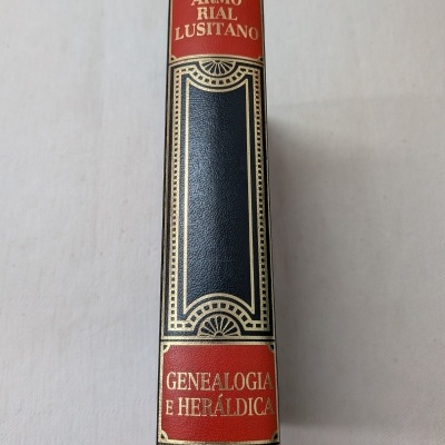 Lombada de livro de couro preto com detalhes vermelhos e dourados intitulado ARMORIAL LUSITANO GENEALOGIA E HERÁLDICA.