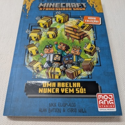 Livro Minecraft Stonesword Saga com personagens e abelhas em capa azul.