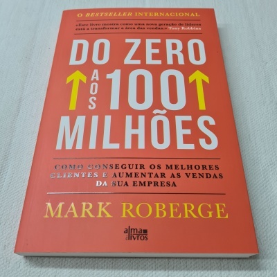 Livro laranja com o título Do Zero aos 100 Milhões de Mark Roberge