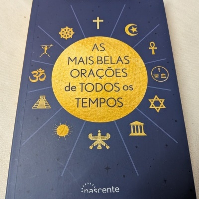 Livro azul escuro com título e símbolos religiosos dourados