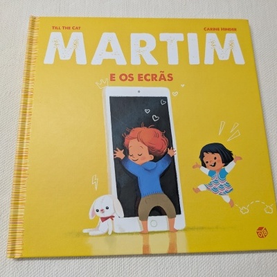Livro infantil amarelo com título MARTIM E OS ECRÃS e ilustrações de crianças e tablet