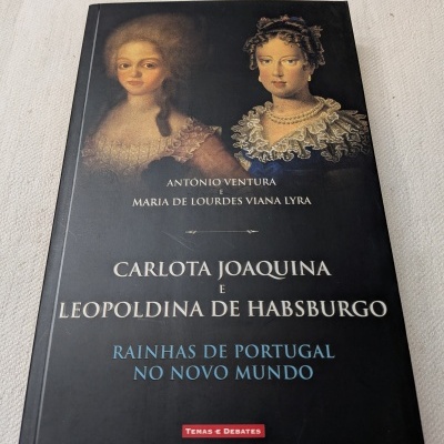 Capa de livro com retratos de duas mulheres históricas e texto sobre histórias de rainhas em Portugal.