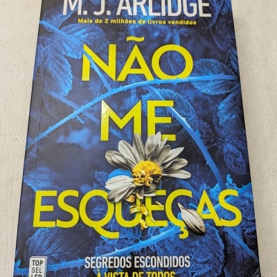 Capa do livro Não Me Esqueças de M. J. Arlidge com flor murcha e fundo azul