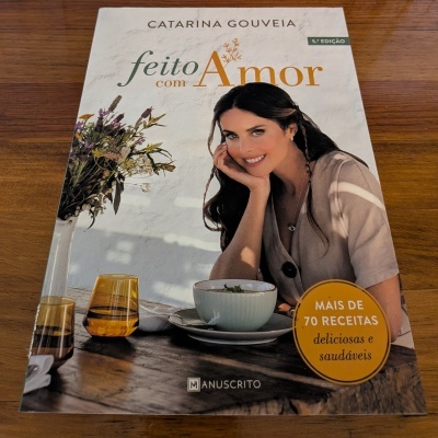 Capa de livro gastronómico com mulher, copos amarelos e selo amarelo