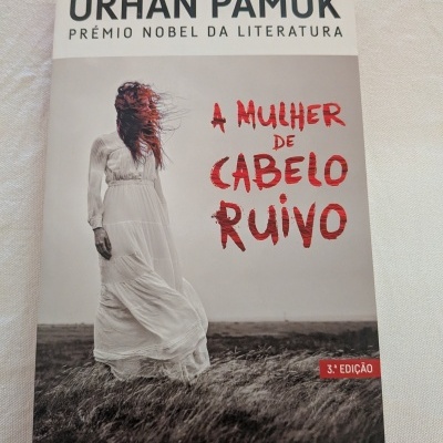 Capa do livro A Mulher de Cabelo Ruivo de Orhan Pamuk com imagem de mulher de cabelo ruivo e vestido branco