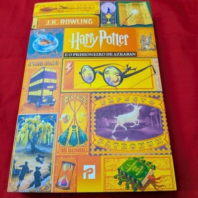 Capa colorida do livro Harry Potter e o Prisioneiro de Azkaban sobre fundo vermelho