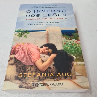Capa do livro 'O INVERNO DOS LEÕES' com mulher e cão em jardim