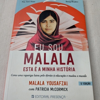 Capa de livro Eu Sou Malala com imagem de rapariga com lenço vermelho e fundo azul e vermelho