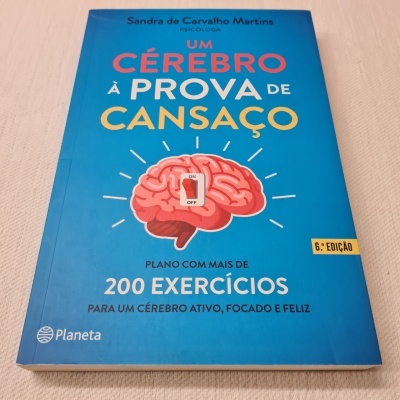 Livro em capa azul com ilustração de cérebro e texto em português