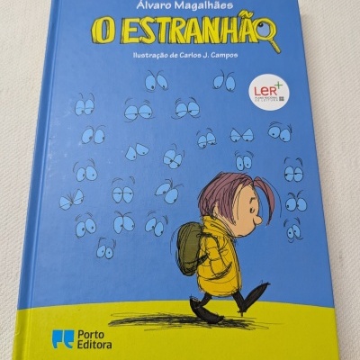 Capa de livro azul e amarela com ilustração de personagem infantil e olhos desenhados
