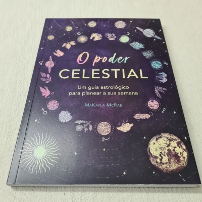 Livro com capa roxa e ilustrações astrológicas