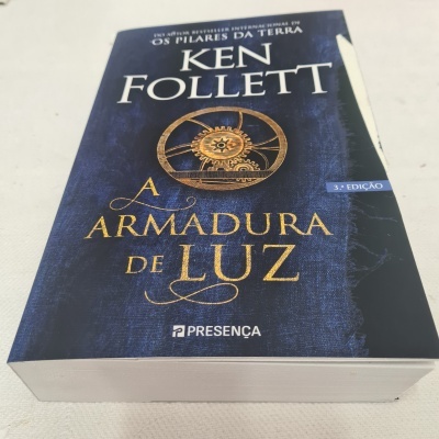 Livro 'A ARMADURA DE LUZ' de Ken Follett com capa preta e dourada
