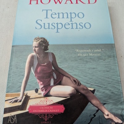 Capa do livro Tempo Suspenso com jovem numa embarcação à beira da água