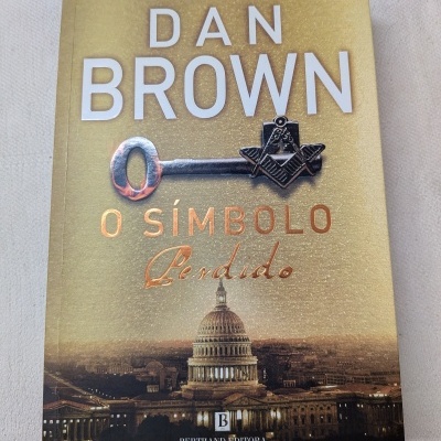 Capa do livro O Símbolo Perdido de Dan Brown com chave e Capitólio ao fundo